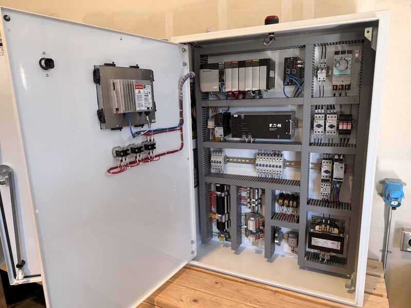 Open control panel with Allen-Bradley PLC, door-mounted operator interface, Ethernet connections and organized wiring.